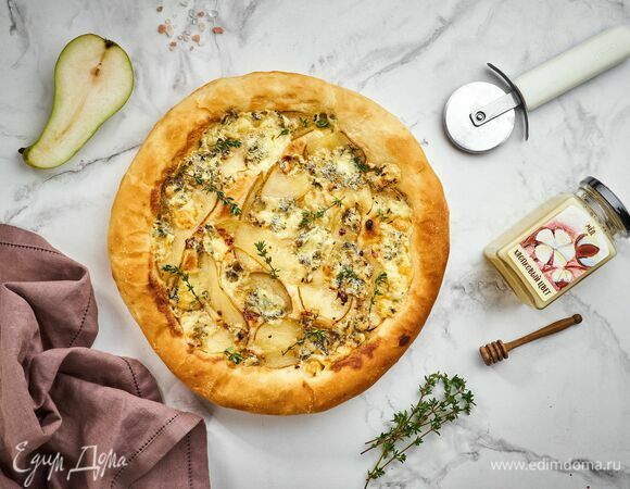 Достаньте пиццу, положите сверху несколько веточек тимьяна и подавайте изысканное угощение к столу.