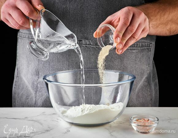 Просейте в чашку муку, добавьте дрожжи, сахар, щепотку соли, влейте 65 мл теплой воды.