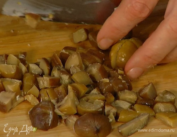 Каштаны нарезать мелкими кубиками, выложить к луку с чесноком и слегка обжарить, затем добавить грибы вместе с вином и все потушить.