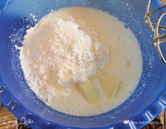 Добавить размягченное масло и сметану. Снова взбить до однородности. Всыпать просеянную муку, крахмал и соду. Перемешать.