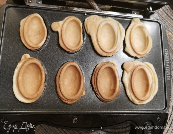 Я выпекаю в мультипекаре, если у вас советская чугунная форма для орешков — прекрасно! Греем ее на плите, заполняем тестом и печем наши половинки до золотистого цвета. Лишнее тесто, вышедшее за края, срезаем.