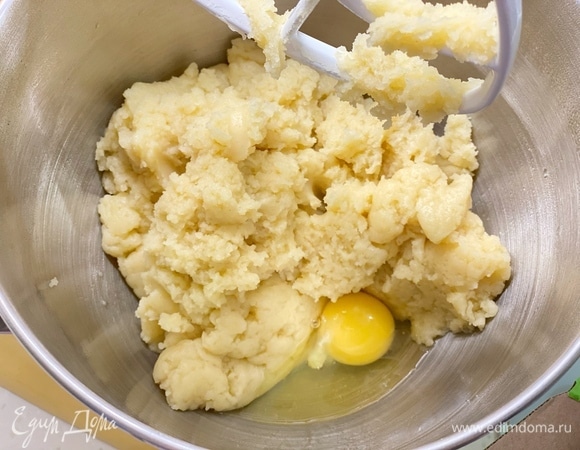 Переложить тесто в чашу миксера, перемешать насадкой для теста и постепенно добавлять яйца до получения блестящего на вид теста. Возможно, потребуются не все яйца. Готовое тесто должно медленно стекать с деревянной ложки.