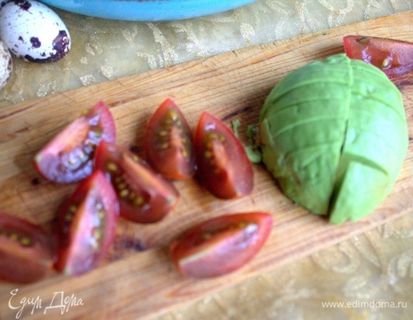 Нарезать авокадо и томаты сорта кумато.
