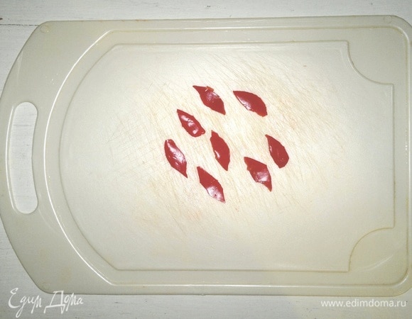 Из красного сладкого перца вырезать кусочки, напоминающие по форме пламя свечи. В каждый морковный цилиндр с начинкой воткнуть кусочки перца.