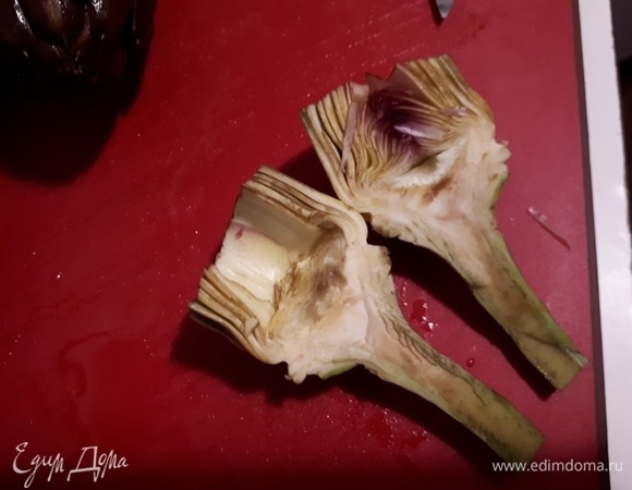 Срежьте верх лепестков (жесткую фиолетовую часть) и разрежьте вдоль. Вычистите внутренние лепестки и волоски на основании цветка. Это лучше делать ложкой. Опустите очищенные артишоки в лимонную воду. Это нужно, чтобы они не почернели.