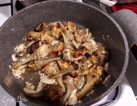 Очистите и раздавите чеснок. Когда артишоки готовы, прогрейте оливковое масло с чесноком на сильном огне, затем быстро обжарьте артишоки.