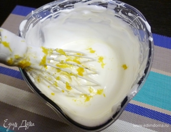 Яйца разделить на белки и желтки. Старайтесь, чтобы желтки не попали в белки, иначе взбить белки в крепкую пену не получится. Белки начать взбивать на средней скорости до образования пены. Затем постепенно всыпать сахар с крахмалом, буквально по чайной ложке. Обязательно небольшими порциями, чтобы сахар полностью растворился. Добавить сок и цедру лимона. Белки должны взбиться в крепкую блестящую пену, до устойчивых пиков.