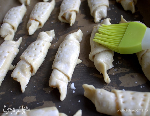 Наколоть верх вилкой, смазать сливками, молоком или яйцом.