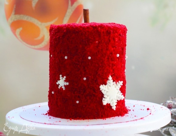 Обрезки от бисквита пробить блендером в крошку. Оставшимся кремом покрыть «башню» (если опасаетесь, что будут видны просветы белого крема, то добавьте в наружный крем красный краситель). Обвалять свечу в бисквитной крошке, задекорировать бусинками, звездами из мастики и так далее.