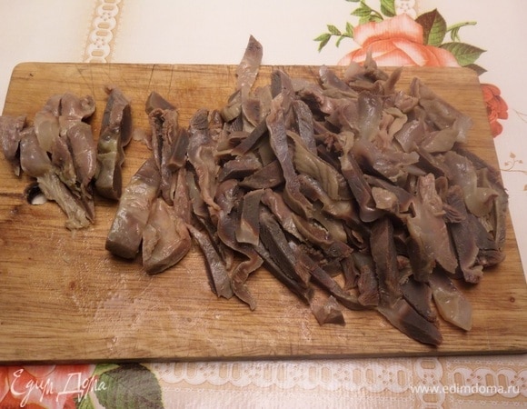 Отваренные куриные желудки нарезаем соломкой.