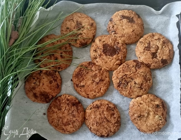 Противень застелить пергаментной бумагой. Из теста скатать шарик, выложить на противень и немного прижать его ладонью. Выпекать печенье в предварительно разогретой вентилируемой духовке при 180°C около 12 минут или в статической духовке при 190°C тоже 12 минут.