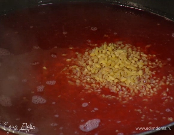 Булгур всыпать в закипающий сок, перемешать и снять с огня, накрыть кастрюлю крышкой и дать крупе впитать жидкость.