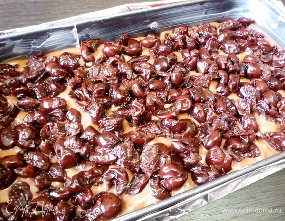 Форму смазать сливочным маслом. Вылить тесто и сверху распределить вишню без косточек, слегка вдавливая в тесто. Форму советую взять разъемную, иначе пропитанный пирог будет проблематично доставать. Дно формы я заворачиваю в фольгу. Тесто достаточно жидкое и может немного вытекать, пока не схватится в духовке.