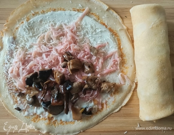 Блинчик смазать соусом, посыпать сыром, выложить ветчину и грибы.