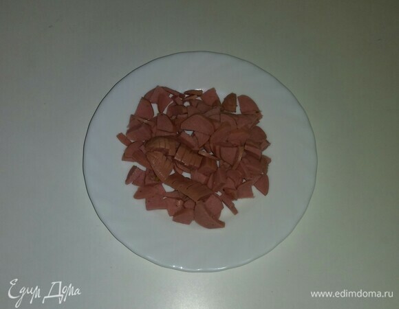 Сосиску нужно нарезать тонкими кольцами, затем разрезать их пополам.