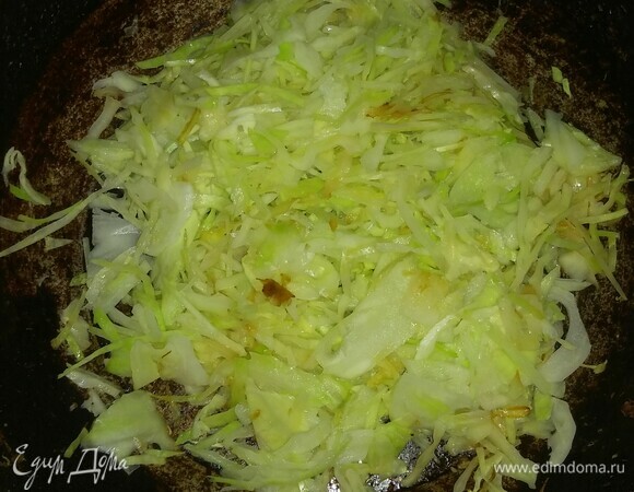 Разогреть сковороду, смазать ее подсолнечным маслом и выложить капусту. Тушить минут 15 на среднем огне мелкой конфорки, а затем добавить к ней натертую морковь, помидоры, сосиску, репчатый и зеленый лук и оливки. Перемешать все вместе, добавить соль и свежемолотую смесь перцев. Тушить еще около 25 минут на среднем огне мелкой конфорки, пока капуста не будет готовой.