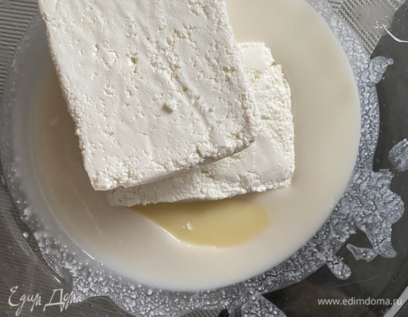 Эскимо у нас будет со вкусом кокоса. Для этого понадобится кокосовая паста, она твердая, ее необходимо прогреть в микроволновке до текучего состояния. В миске смешиваем творог, сгущенное молоко и пасту.