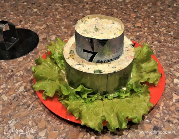 На посуду для подачи выложить листья салата. Поставить кулинарное кольцо и заполнить его салатной смесью. Сверху поставить еще одно кольцо меньшего размера (я его сделала из банки из-под пива). Так же заполнить получившейся смесью. Убрать в холодильник на 1 час, чтобы майонез связал все компоненты, а салат приобрел форму колец.