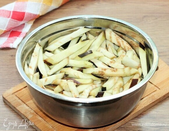 Заливаем баклажаны горячей водой и добавляем лимонный сок (0,5 лимона) или 9% уксус (1,5 ст. л.) и соль (1,5 ст. л.), перемешиваем.