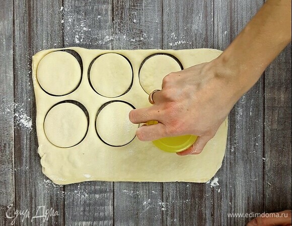Слоеное дрожжевое тесто комнатной температуры немного раскатываем. Вырезаем круги. Диаметр моих — 6,5 см.