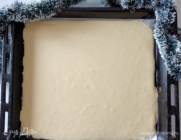 Противень застелить пергаментной бумагой, выложить и распределить тесто.
