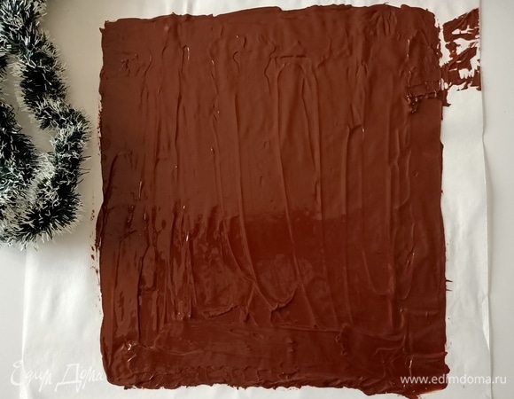 Шоколад измельчить и растопить на водяной бане. Выложить на пергаментную бумагу, распределить тонким слоем.