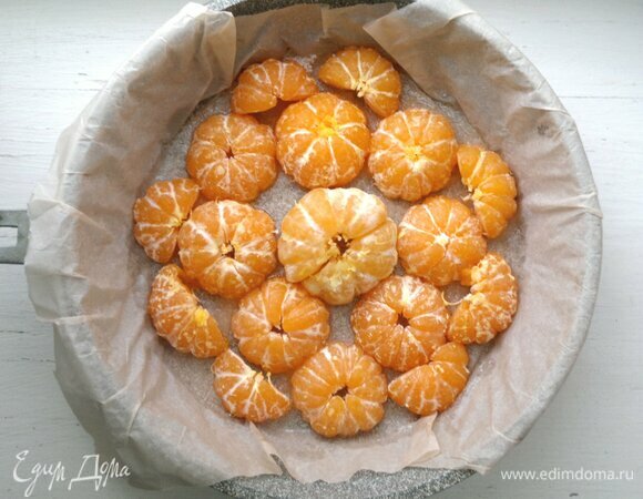 В форму выложить половинки мандаринов срезом вниз.
