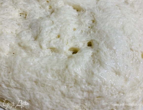 Тесто со всех сторон щедро посыпаем мукой. Подравниваем стороны, чтобы получился ровный прямоугольник. И совсем слегка, аккуратно растянем тесто. Нажимать на тесто нельзя, чтобы пузыри внутри не полопались.