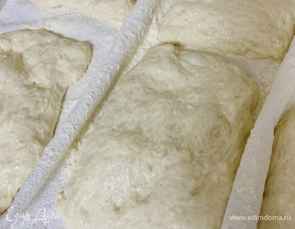 Накрытые чиабатты оставляем для расстойки на 30 минут и включаем духовку на 220–240°C. Противень переворачиваем вверх дном и оставляем нагреваться в духовке.