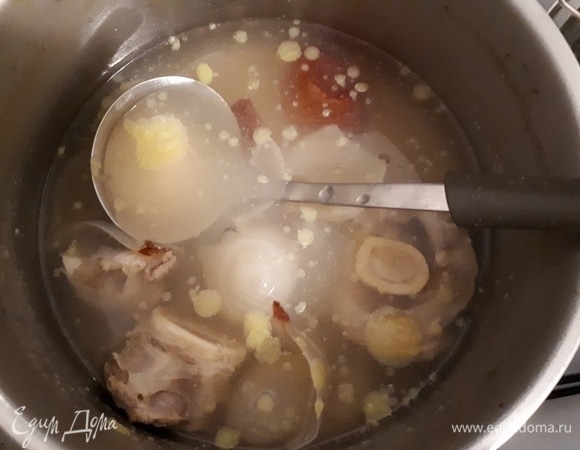 Сварите бульон из куриной ножки. Вымойте лук, отрежьте корень, разрежьте вдоль пополам и прижгите на сухой сковородке. Положите лук в бульон для цвета и варите примерно полтора часа. Можно, в принципе, сэкономить время и сделать бульон из кубика, но натуральный бульон лучше. Нам понадобится 750 мл бульона.