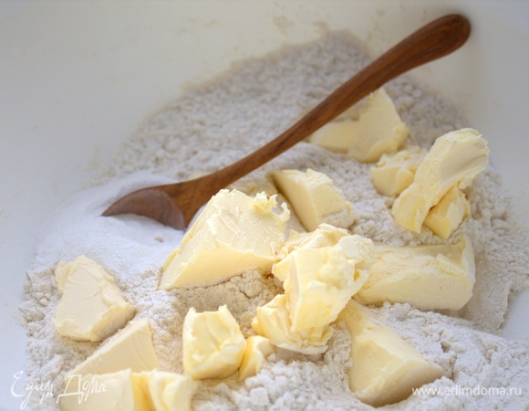 В муку (не всю, оставить около стакана) с разрыхлителем нарезать масло.