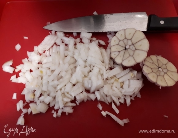 Нарежьте лук кубиками. Снимите верхнюю шелуху с чеснока, вымойте его и разрежьте всю головку пополам.