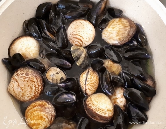 Положите ракушки сверху на листья капусты и прогрейте пару минут. Затем влейте вино и бульон, посолите, положите сверху петрушку и накройте капустными листьями.