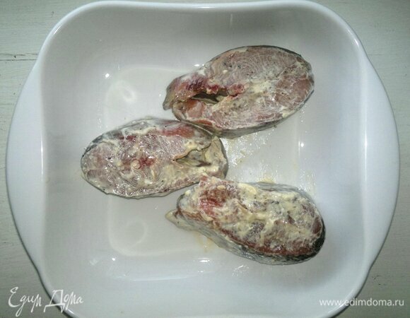 Рыбные стейки вымыть, обсушить бумажным полотенцем. У меня стейки кеты. Сметану соединить с лимонным соком, перемешать. Рыбу немного посолить, поперчить, смазать частью сметаны, дать полежать 8–10 мин. Форму для запекания смазать растительным маслом, выложить стейки в форму.