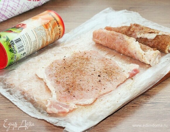 Посыпаем свиные отбивные молотой приправой (1 ч. л. для свинины) с двух сторон и скатываем в рулет, убираем в сторону. У меня приправа с добавлением соли и перца.