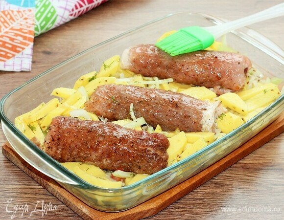Кладем мясные рулетики на картофель и смазываем верх рулетов маслом. Закрываем формочку фольгой и отправляем в разогретую до 180°C духовку на 30 минут или до готовности мяса.