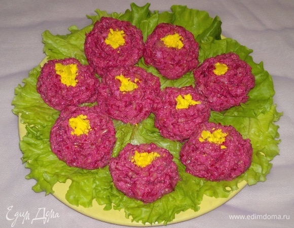 Листья салата вымыть, обсушить бумажным полотенцем. В шариках сформировать небольшое углубление, а краем ложки сделать на шарике небольшие насечки, имитируя лепестки розы или пиона. В середину каждого «цветка» положить немного раскрошенного желтка. Закуску можно сразу подать на стол или поставить в холодильник и держать там до подачи.