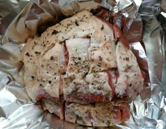 Достать мясо из холодильника. Завернуть свинину в два слоя фольги, выложить на противень и поставить в духовку, разогретую до 180°C , на 1 час.