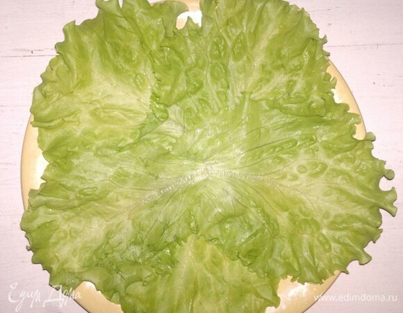 Листья салата вымыть, обсушить. Застелить ими плоское блюдо.