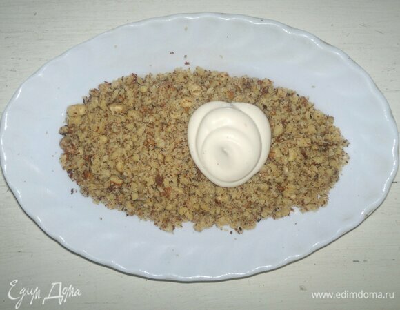 В орехи добавить домашний майонез, перемешать. Ореховой массой покрыть туловище ежа. Мордочку посыпать сыром, выровнять чайной ложкой.