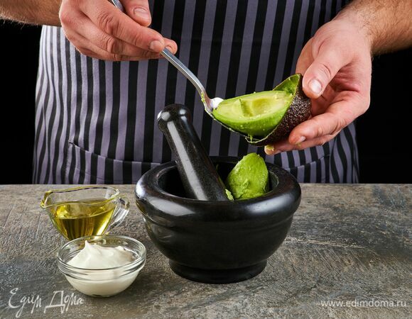 Авокадо очистите и тоже переложите в ступку. Добавьте сметану и оливковое масло.