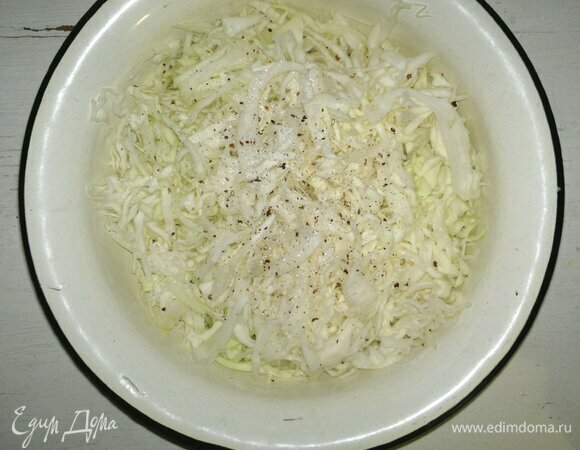 Сложить капусту в миску, немного посолить и поперчить, помять руками.