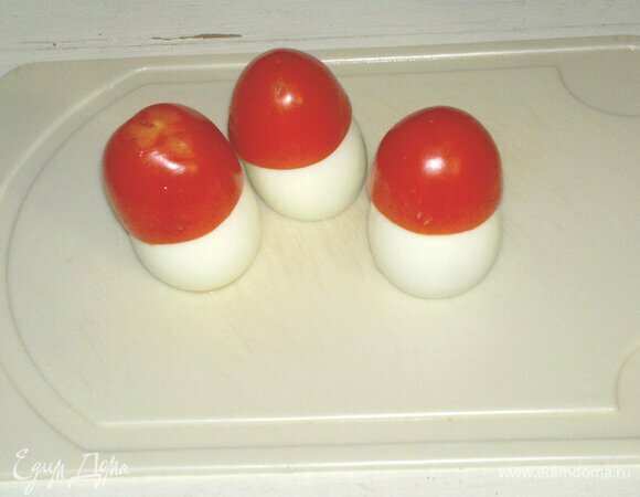 Для украшения почистить мелкие вареные яйца. С одного конца отрезать немного белка, чтобы яйца устойчиво стояли. Надеть на яйца помидорные шляпки, получились грибки.