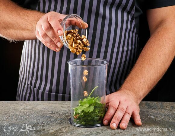 В чаше блендера соедините зелень и орехи.