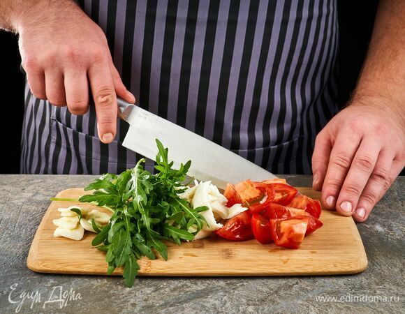 Помидоры и руколу вымойте, обсушите. Помидоры нарежьте крупно, моцареллу нарежьте кубиками, чеснок крупно нарубите.