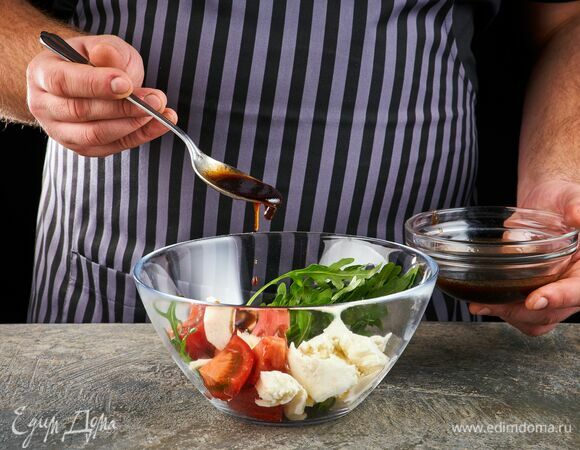 Получившимся соусом заправьте выложенные в салатник руколу, помидоры, моцареллу и чеснок.