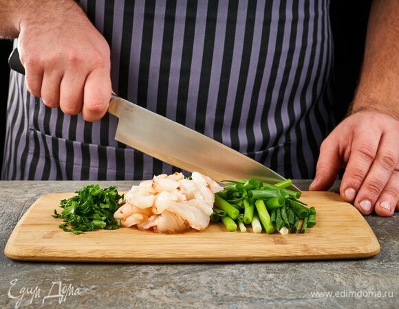 Зеленый лук нарежьте брусочками, петрушку мелко нарубите, креветки очистите и разрежьте вдоль.