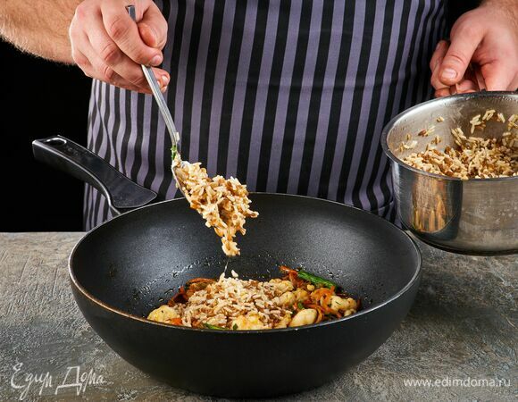 Всыпьте смесь из бурого риса, полбы и семян льна. Обжаривайте около минуты.