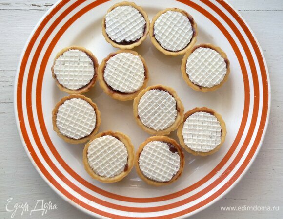Вафельными кружками закрыть донышки пирожных. Поставить заготовки в морозилку на 5–8 минут.