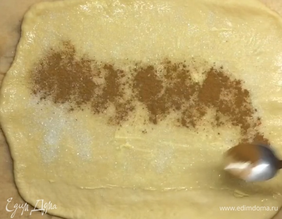 Тесто готово, раскатываем его в виде прямоугольной формы, смазываем мягким сливочным маслом, отступая по 2–3 см с двух сторон, посыпаем корицей и сахаром.